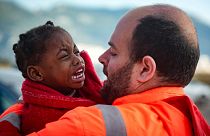 A spanyol tengeri mentőszolgálat egyik munkatársa tart karjában egy kimentett migránsgyermeket 2022. október 27-én