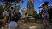 Personas toman fotos frente a la Basílica de la Sagrada Familia en Barcelona, España.