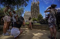 Personas toman fotos frente a la Basílica de la Sagrada Familia en Barcelona, España.