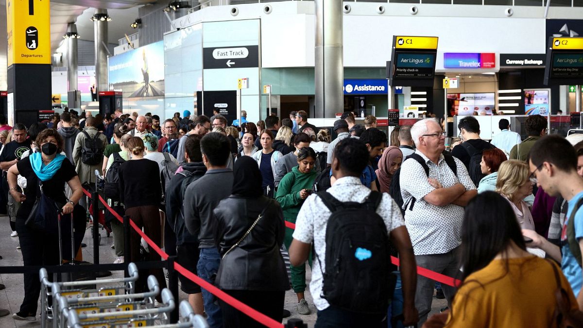 Passengers queue inside the departures terminal of Terminal 2 at Heathrow Airport in London in July 2023.