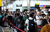 Passengers queue inside the departures terminal of Terminal 2 at Heathrow Airport in London in July 2023.