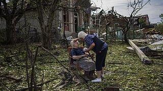 Δύο γυναίκες μπροστά από το κατεστραμμένο σπίτι τους στην ανατολική Ουκρανία