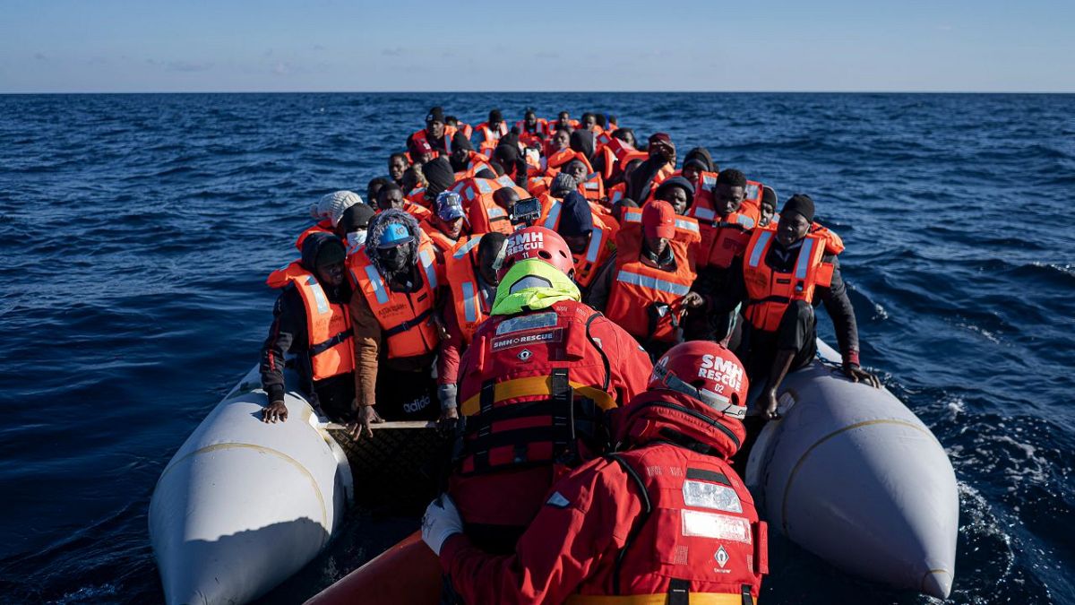 Migrants and refugees from Africa sailing adrift on an overcrowded rubber boat, are assisted by aid workers of the Spanish NGO Aita Mary in the Mediterranean Sea. Jan 2022