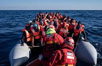 Migrants and refugees from Africa sailing adrift on an overcrowded rubber boat, are assisted by aid workers of the Spanish NGO Aita Mary in the Mediterranean Sea. Jan 2022