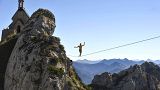 A Slackliner walks on a highline at Wendelstein mountain near Bayrisch Zell ,in the Bavarian Alps, southern Germany
