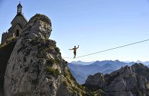 A Slackliner walks on a highline at Wendelstein mountain near Bayrisch Zell ,in the Bavarian Alps, southern Germany