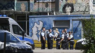 Police officers secure a crime scene in front of a school in Esslingen.