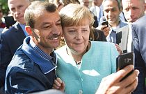 2015'te Suriyeli mültecilere Almanya'nın kapılarını açan Başbakan Angela Merkel'le fotoğraf çektiren bir sığınmacı