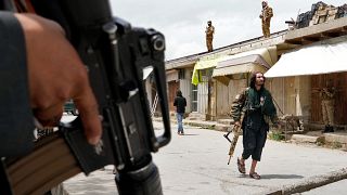 Taliban fighters stand guard at the site of an explosion in front of a school, in Kabul on 19 April 2022
