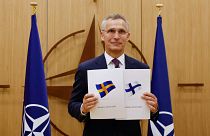 NATO Genel Sekreteri Jens Stoltenberg İsveç ve Finlandiya bayraklarıyla