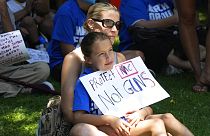 Una niña con un cartel que lee "Protéjanme a mi, no a las armas"