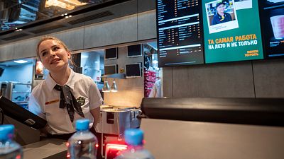 A staff member speaks with visitors at a newly opened fast food restaurant in a former McDonald's outlet in Bolshaya Bronnaya Street in Moscow,, 12 June 2022