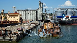 A sunken Ukrainian warship is seen near the pier with the grain storage in the background at an area of the Mariupol Sea Port, 12 June 2022