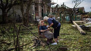 Elena Holovko sits among debris outside her house damaged after a missile strike in Druzhkivka, eastern Ukraine, 5 June 2022