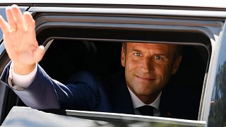 France's President Emmanuel Macron waves as he leaves the polling station after voting in the first round of French parliamentary election on 12 June 2022