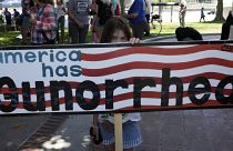 Участница протеста за ужесточение контроля за оружием с плакатом "У Америки Gun-орея"