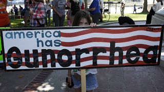 Участница протеста за ужесточение контроля за оружием с плакатом "У Америки Gun-орея"
