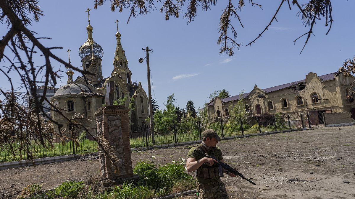 Украинский военный на фоне церкви в одной из деревень близ передовой в Донбассе