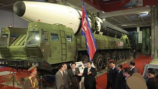 الزعيم الكوري الشمالي كيم جونغ أون يقف أمام ما ما تقزل كوريا الشمالية إنه صاروخ باليستي عابر للقارات عُرض في معرض في بيونغ يانغ في أكتوبر