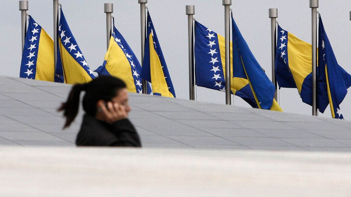 زن بوسنیایی در کنار پرچم های  بوسنی و هرزگوین در سارایوو. 