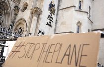 Протест у Королевского судного двора в Лондоне. Плакат с надписью "Остановите самолет". 13 июня 2022 года