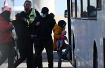 کودک خردسال با جمعی از مهاجران سوار بر اتوبوس می‌شوند