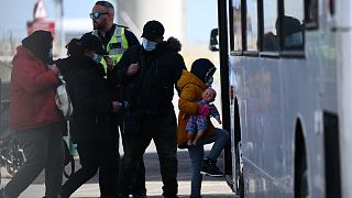 کودک خردسال با جمعی از مهاجران سوار بر اتوبوس می‌شوند 