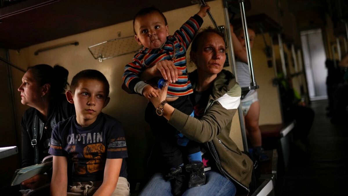 Yana Skakova and her son Yehor who fled from Lysychansk with other people sit in an evacuation train at the train station in Pokrovsk, eastern Ukraine, Saturday, May 28, 2022.