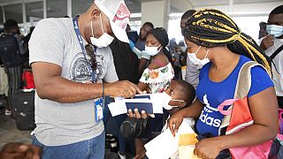 Haitianos esperan para subirse a un vuelo chárter en dirección a Chile en el aeropuerto de Puerto Príncipe, Haití