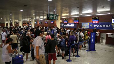 Passengers wait to check in at Ryanair desk at Barcelona airport in Prat Llobregat, Spain.