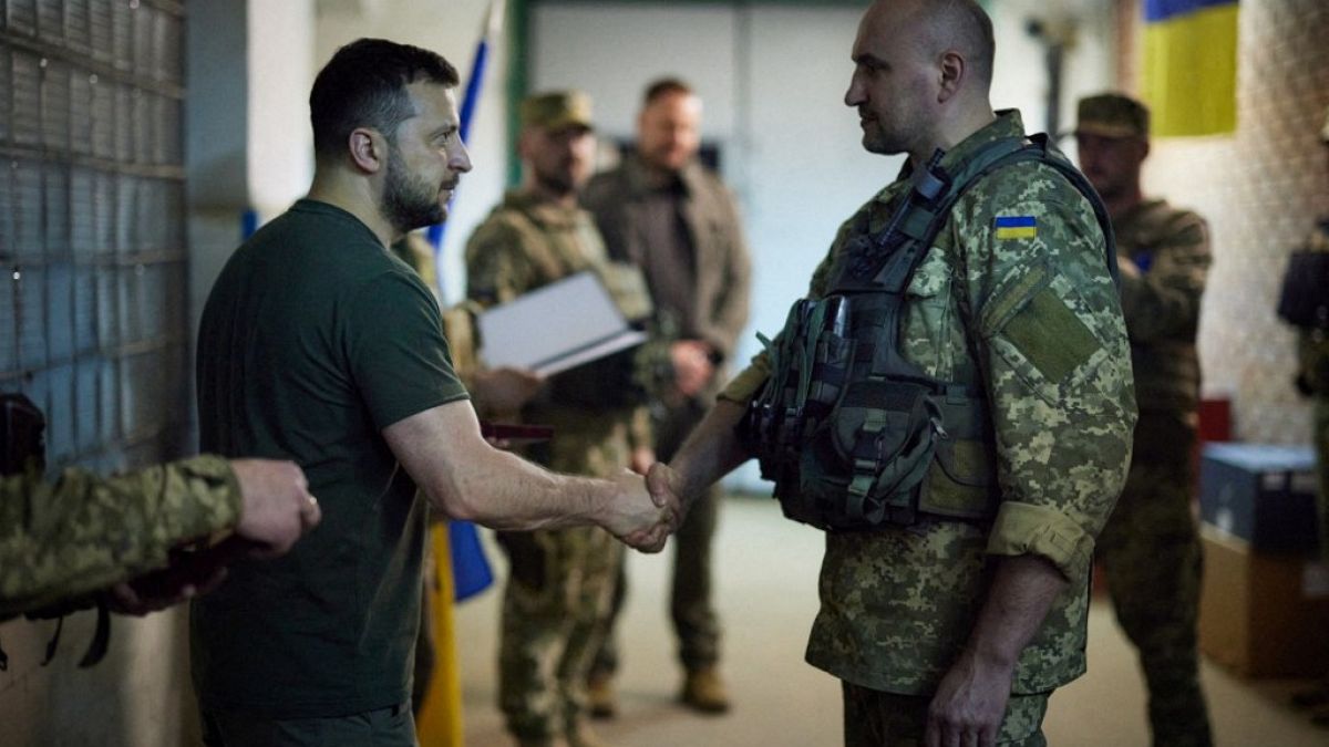 June 6, 2022, Ukrainian president Volodymyr Zelenskyy shakes hands with a Ukrainian serviceman during a visit to the frontline. 