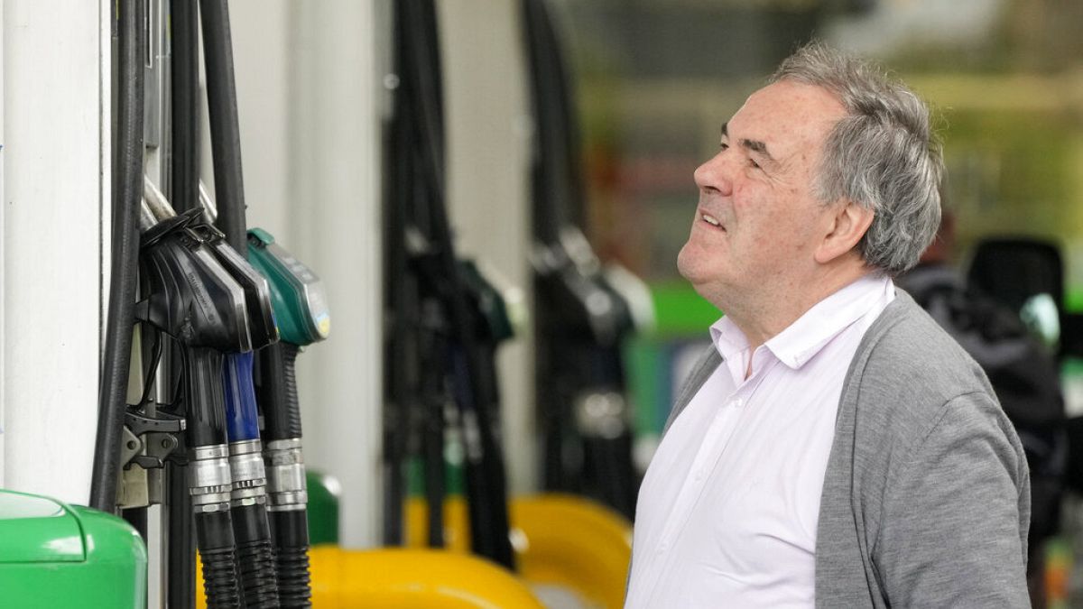 Un hombre mira el contador en una gasolinera del Reino Unido