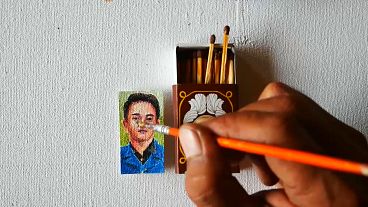 Iwan Ridwan painting a small portrait.