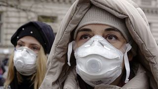 Women wearing face masks take part in a protest against air pollution, in Sarajevo, Bosnia, Monday, Jan. 20, 2020.