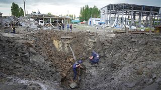 Egy orosz rakéta kráterét vizsgálják tűzszerészek a kelet-ukrajnai Pokrovszkban