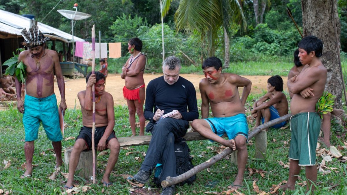 November 15, 2019 veteran foreign correspondent Dom Phillips (C) takes notes as he talks with indigenous people at the Aldeia Maloca Papiu, Roraima State, Brazil. 