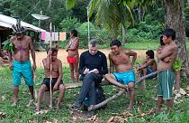 November 15, 2019 veteran foreign correspondent Dom Phillips (C) takes notes as he talks with indigenous people at the Aldeia Maloca Papiu, Roraima State, Brazil.