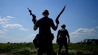 A civilian militia man holds a shotgun and a rifle during training at a shooting range in outskirts Kyiv, Ukraine, Tuesday, June 7, 2022