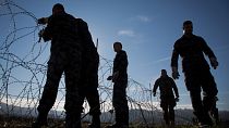 Slovenian soldiers erect a razor-wired fence on the Croatian border in Gibina, Slovenia, Wednesday, Nov. 11, 2015