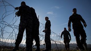 Slovenian soldiers erect a razor-wired fence on the Croatian border in Gibina, Slovenia, Wednesday, Nov. 11, 2015