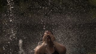 امرأة تنتعش بمياه في نافورة في حديقة في العاصمة مدريد - إسبانيا. 2022/06/15
