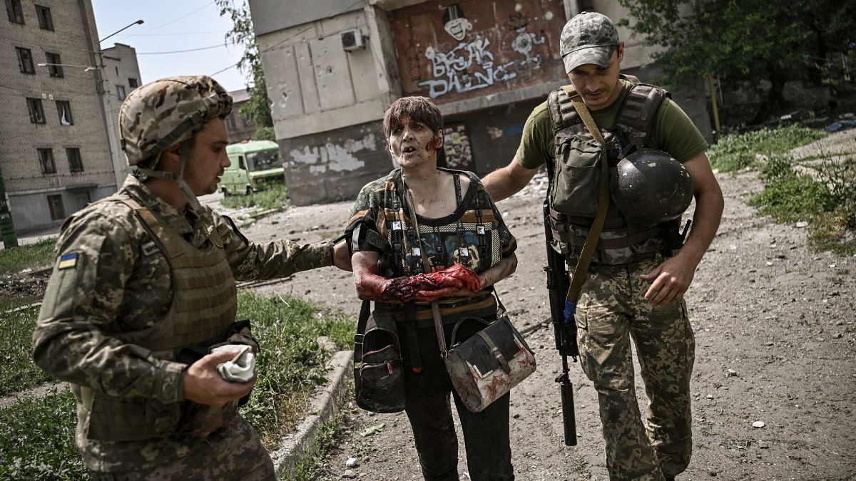 Une femme blessée et des militaires ukrainiens à Lysychansk, Ukraine , 11 juin 2022.