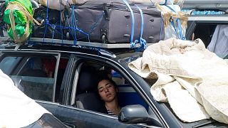 A woman sleeps in a car as vehicles wait their turn to board ferries in the port of Algeciras. Spain Monday Aug. 5, 2103.