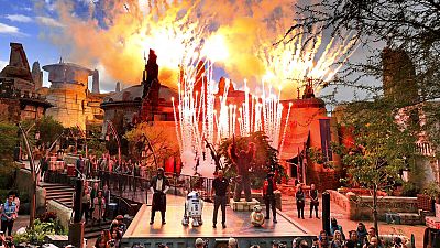 Fireworks blast during the dedication ceremony with invited guests at the entrance of the Star Wars: Galaxy's Edge attraction at Disney's Hollywood Studios, August, 2019.