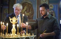 Selenskyj und Johnson entzünden während eines Kirchenbesuchs Kerzen