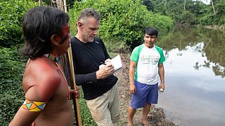 November 16, 2019 Veteran foreign correspondent Dom Phillips (C) talks to two indigenous men in Aldeia Maloca Papiú, Roraima State, Brazil.