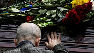 Anciano asistiendo al funeral del activista muerto en combate, Roman Ratuchny