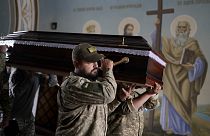 Soldiers carry the coffin of activist and soldier Roman Ratushnyi for his memorial service in Kyiv, 18 June 2022