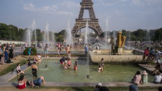 People enjoy the sun and the fountains of the Trocadero gardens in Paris.