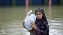 طفلة بنغالية تحمل مواد إغاثة في منطقة كومبانيغونج في سيلهيت التي تضررت بفعل الفيضانات،  20 يونيو 2022.